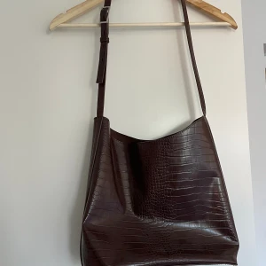 Väska - Väska i brun skinnimitation från Carin Wester. Använd men i fint skick.