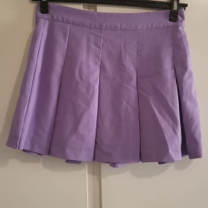 Kjol - Ljuslila kjol. Dragkedja vid sidan.