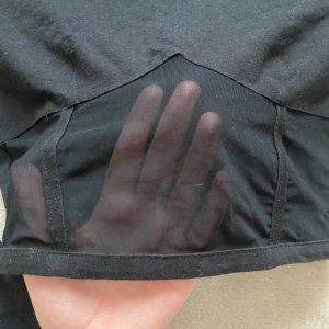 Svart cropped långärmad tröja - Tröja från Na-Kd med halv polokrage. Snygg design under bysten, ger korsett liknande effekt. Är cropped. Använd en gång. Är i storlek 34 men passar mig utan problem som är en storlek 36-38, då den är väldigt stretchig. 