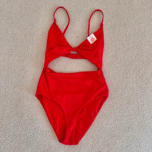 BikBok röd baddräkt med cut-out - Baddräkt från BikBok med cut-out vid naveln. I nyskick, endast provad.