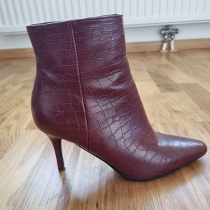 Vinröda ormskinnsklackar - Storlek 38, ormskinnsimitation,  vinröd, smal klack. Jättebra skick, knappt använda.