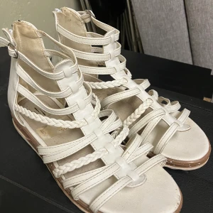 Sommarsandal skinnimitation - Vit sommarsandal i skinnimitation i jättefint skick. Strl 37. Obetydligt använda. 