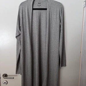 Uniqlo cardigan - Tunn cardigan med slits från Uniqlo. Stl S, köpt i Vietnam.  Bra skick och säljer enbart pga för liten för mig. 