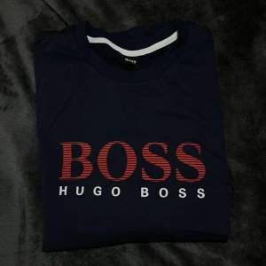 Långärmad mörk blå Hugo boss med röda detaljer. Ny, beställde fel storlek inte haft tid att returnera. Säljer billigt!