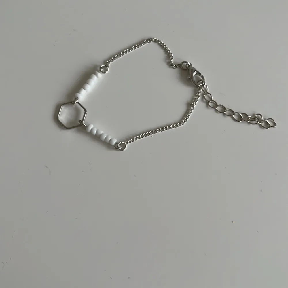 Ett armband i silver med vita pälor. Storleken passar inte så bra för barn.. Accessoarer.