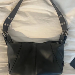 Svart liten handväska - Lägger ut igen!Jäätte jätte fin men lägger ut den då jag har lite för många väskor för tillfället. Inga defekter skulle jag säga. Ett fack inuti med dragkedja som ni ser på andra bilden! Det får plats mer i än vad man tror!! Skriv vid funderingar!