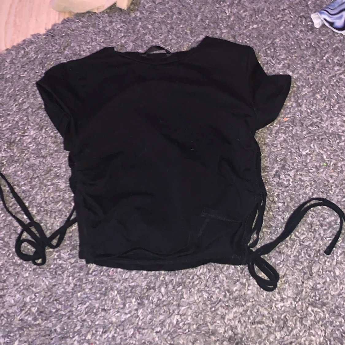 svart topp med snören på sidorns