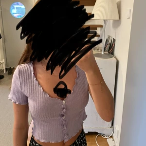 Lila magtröja med knappar - En söt lila magtröja ihopsatt med knappar. Super fin kort t-shirt med u-ringningz