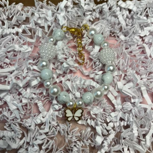  Vitt armband Med berlock  - Vitt armband med berlock som går att justera.