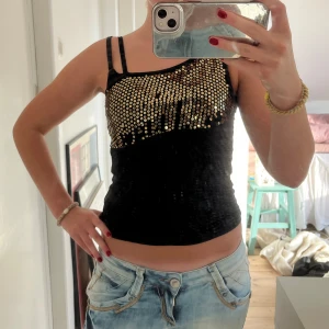 Festtopp med paljetter - Så cool svart oneshoulder topp med guldiga paljetter