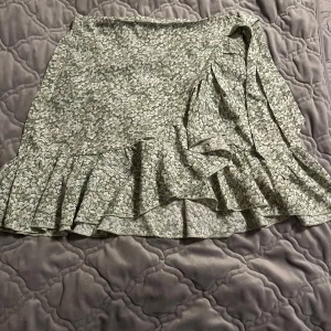 Blommig kjol - Säljer denna gröna blommiga kjolen från SHEIN. Köpt för 3 år men är endast använd 2 ggr i år och Max 5 ggr åren innan. Originalpriset är 150kr. Pris kan diskuteras, kom privat för fler bilder.Jag säljer denna då den inte kommer till användning längre