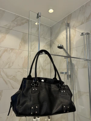 Handväska  - Handväska med silverdetaljer, köpt secondhand, vet ej märke. 19cm höjd, 35 cm bredd.