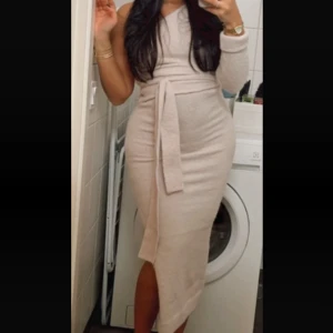 Stickad klänning - Beige/naturvit stickad klänning med en ärm. Formar kroppen fint. XX-Small. Passar upp till S. Aldrig använd, bara testad. Därmed inga skador. Köptes för 649 kr.  Pris kan diskuteras!