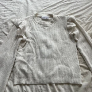 Stickad tröja med volang  - Denna stickade tröja från vila är som nu då den är använd fåtal gånger. Säljer då jag inte använder den och den har inga som helst defekter. Kom privat för fler bilder om så önskas🤍