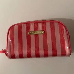 Victoria’s Secret necessär - Säljer denna necessär från Victorias’s Secret. Den är köpt i butik i Stockholm för flera år sedan men är fortfarande i väldigt fint skick. Storlek ca 16x10 cm :)
