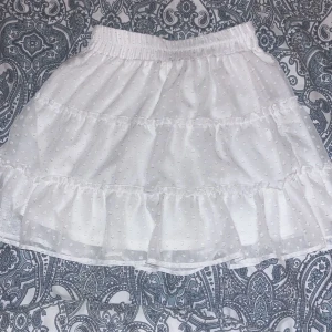 Vit sommarkjol - Söt sommarkjol som jag inte längre får användning av 🤍 Köpt för någon sommar sen, men sporadiskt använd. Inga fläckar, hål eller liknande. Man kan ha den både hög- och lågmidjad. Djur och rökfritt hem!