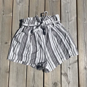 H&M - grå vita shorts - Söta sommarshorts ifrån H&M. Väldigt fina och passar till mkt men är för små för mig. Storlek 34. Använd fåtal gånger.💖