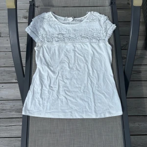 T-shirt med spets - Vit t-shirt med spets på överdelen! Jättefin nu till sommaren men funkar även året om! 