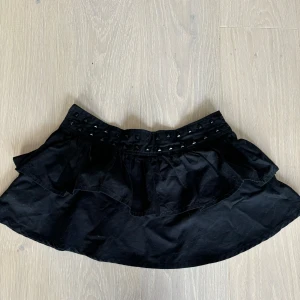 Cool minikjol med nitar - Säljer denna mini kjol i tyg material med nitdetaljer längs midjan Den är i st xs men skulle säga att den passar s också