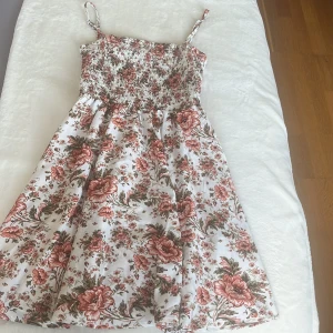 Blommig klänning - Jättefin kort klänning som är perfekt till sommaren, den är aldrig använd utan bara prövad. Säljer för att den ej kommer till användning 