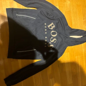 Hugo boss hoodie - Säljer tröjan pga av att jag har vuxit ur den. Den har defekter som slitet tyg som syns på bilderna men inget annat utom det. Priset kan förhandlas