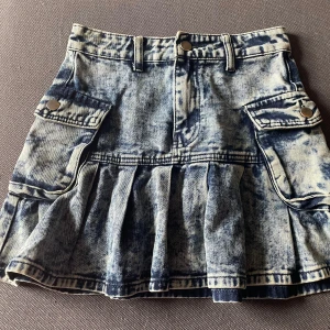 Jeans kjol - En fin high Rise jeans kjol med coola fickor på sidan då jag säljer den för att den är lite kort. Den är 36 cm lång och 34 cm rakt över. Inga skador💕 kontakta för mer information.