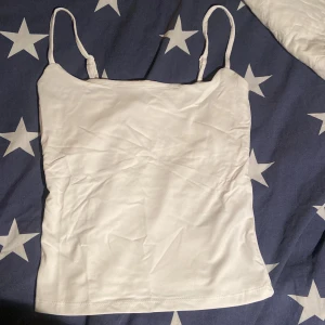 vitt linne - Ett vanligt jätteskönt linne!! Det är typ lite sport material som gör att den sitter snyggare och skönare. Säljer dp jag köpte fel storleks. Han dock att riva av lapparna men den ör endast testat. original pris 150kr men köpt på rean för 74kr. 