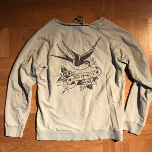 Ed hardy tjock tröja  - Ljusblå ed Hardy tjock tröja med print på ryggen!! super mysig tröja men knappt använd då det inte är min stil 😽