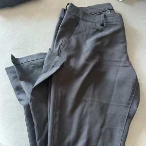 Lågmidjade kostymbyxor - Storlek 44, ganska använda men omhändertagna. Passar mig som är en 40 i vanliga fall, ganska långa. Jag är 162 och de är för långa för mig, men jätte fina på med slits på benet.  Nypris 499kr på Bik Bok!