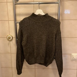 Stickad tröja  - Skit snygg stickad brun tröja med  guld detaljer. Den kommer tyvärr inte till användning. Är som ny! Står att den är storlek L men skulle säga att den är i S/M snarare.