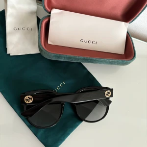 GUCCI SOLGLASÖGON  - Svarta solglasögon från Gucci, i modellen GG0035S 001. Modellen säljes ej längre. Nypris 2769kr. Inga skador eller defekter, all tillbehör kommer med. 
