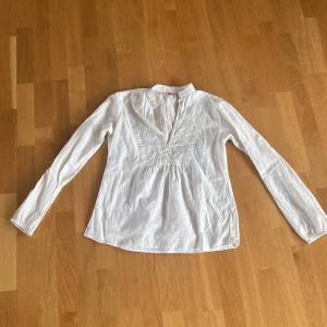 Sommarblus - Vit, långärmad blus med krage och mönster/broderier av blommor. Perfekt inför sommaren! 