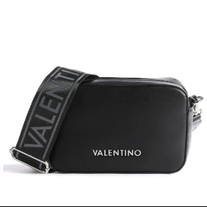 Valentino bags väska - Valentino bags väska i svart. Tror modellen heter camera bag! Kommer med 2 olika band. På de tjocka bandet har det försvunnit lite av den silvriga färgen på metallen, som syns på sista bilden. Säljes då den inte kommer till användning