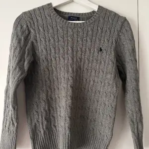 Tja, säljer den här fina grå polo ralph lauren cnable kitt cotton sweater. Nästan helt oanvänd skicket ( 9/10 ) storlek- 10-12 ( M i junior ). Nypris 1395 kr, mitt pris 299 Hör av er vid fler frågor och bilder. Säljer pågrund av att den är för liten