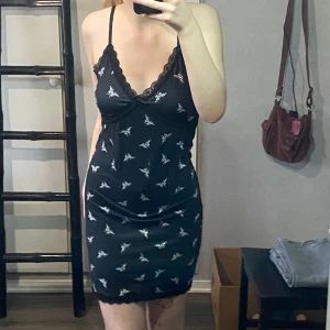 Fjäril klänning  - Den är för stor och alldrig använd, spets längs med slutet/ kanten av kjoltrender samt vi brösten+ en rosett i mitten, väldigt fin men som sagt för stor.