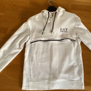 Otroligt snygg Emporio Armani hoodie - Säljer nu en otroligt fin vit Emporio Armani hoodie! Strl: M. Hoodien har inga skador eller fläckar. Skriv vid frågor eller funderingar!