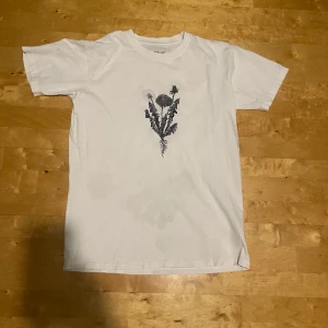 Broderad Blom tshirt - En mycket fin vit T-shirt med en broderad maskros på. Kan diskutera pris
