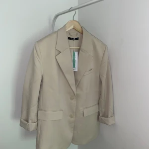 Oversized blazer i beige färg från Gina Tricot XS - Säljer en superfin oversized blazer som är helt slutsåld på Gina Tricot. Kavajen är helt oanvänd med lapparna kvar. Säljs då jag köpte en liknande samtidigt som jag använder. Nypris ca 699kr ✨
