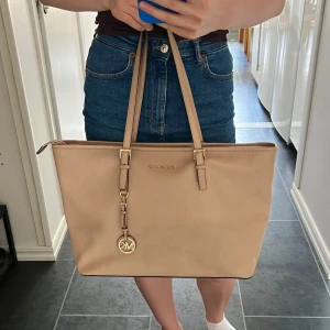 Michel kors väska  - Michael Kors väska använd men i gott skick. Längsta bredd ca 47 cm. Köpte för ca 3500 kr, pris kan diskuteras🧡💫