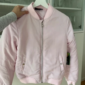 Rosa bomberjacka - Helt oanvänd med prislapp kvar. Passar XS även fast det är barnstorlek. Hör av er vid fler frågor.