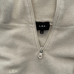 LXA fleecetröja  - Jätteskön fleecetröja från LXA the Label i storlek XS. Som ny förutom att dragkedjan är lite sliten. Stor i storleken. 