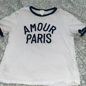 Figursydd T-shirt i mjuk bomullsjersey med tryckt motiv framtill - Längd: Kort Ärmlängd: Kort ärm Passform: Slim fit Halsringning: Rundhalsad Beskrivning: Vit/Svart, Amour Paris