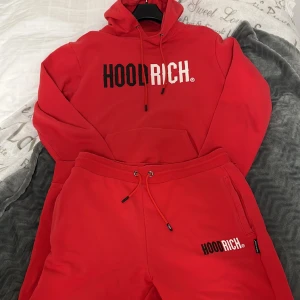 Hoodrich tracksuit - Röd hoodrich tracksuit i nyskick. Använt 3-5 gånger som set. Inga tecken på användning. Hoodien är i storlek M men skulle säga att den även passar L. Byxorna är i XL, men små i storleken så passar L bättre. Byxor säljs separat, hoodien endast i set.