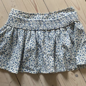 Kjol - En blommig kjol i vitt och blått. Passar både XS och S! Klicka inte på köp nu. 