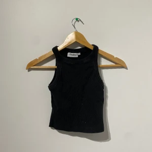 croppad tanktopp - en svart topp från junkyard som används många gånger men är fortfarande i bra skick. sitter tajt och är croppad.
