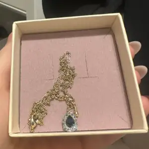 Fint halsband med guld kedja och en blå sten. Halsbandet är från Lily & Rose och har aldrig kommit till användning🩷 Smyckesask tillkommer💕