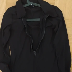 One pize - Helsvart OnePiece med dragkedja fram och långa armar, storlek large, inte använd