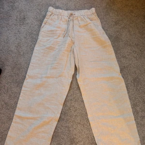Beiga linnebyxor  - Beiga linnebyxor från Arket. Använda ett fåtal gånger så dom är i bra skick! Säljer då dom inte kommer till användning längre. Midjemåttet tvärs över är 33cm men midjan är ganska töjbar och innerbenslängden är 68cm.