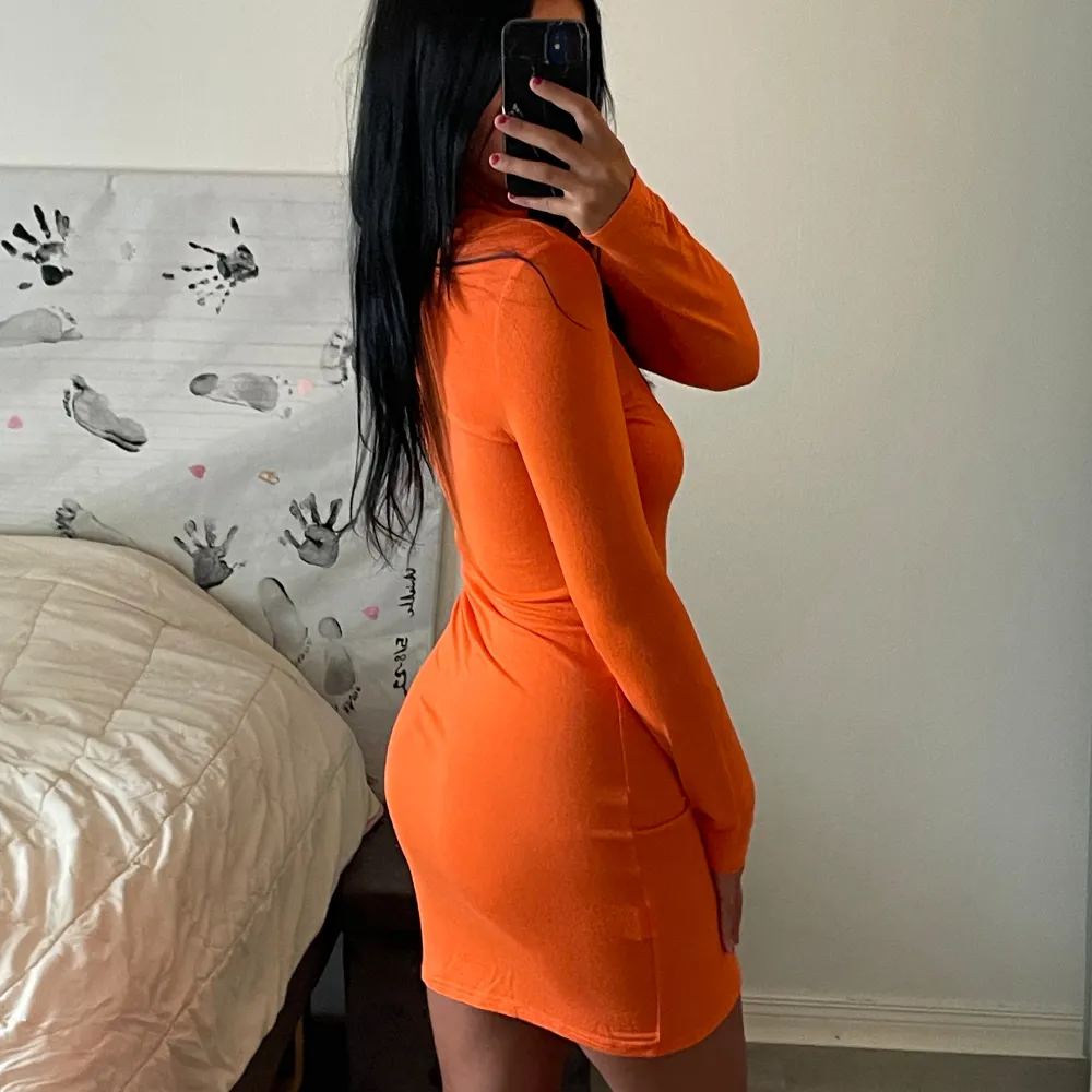 En orange klänning med hög hals. Aldrig kommit till användning då jag sällan har på mig klänningar. Super fint att ha på sig till sommarkvällar. Klänningar.