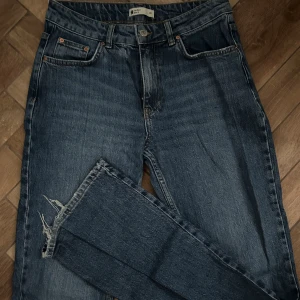 Bootcut jeans - Ett par skitsnygga bootcut jeans från Gina tricot! Det finns ett litet hål som syns på andra bilden men annars inga defekter! 